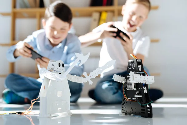 Meninos felizes brincando com seus novos brinquedos robóticos — Fotografia de Stock