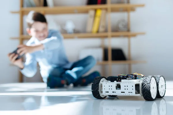 Liten pojke nedsämkmimg i leker med robotic bil — Stockfoto
