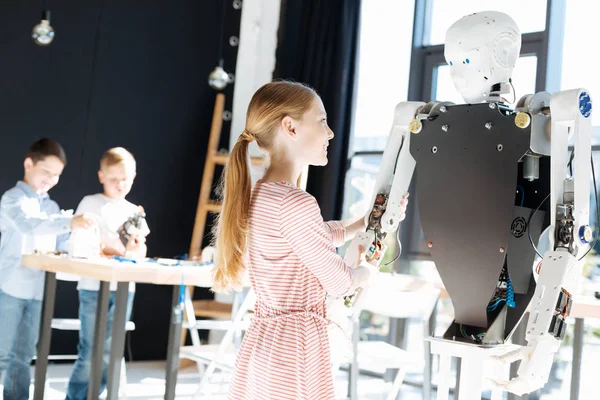 Küçük kız bir robot elini tutarak heyecanlı