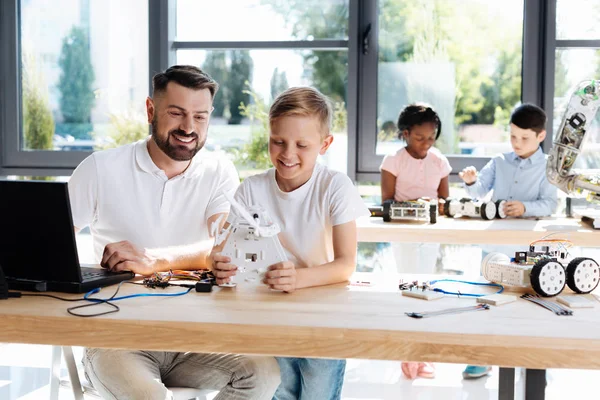 Teacher and student testing newly created robot — Stock Photo, Image