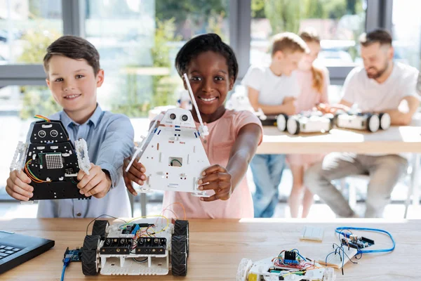 Adorable girl and her friend posing with robot models — Stock Photo, Image
