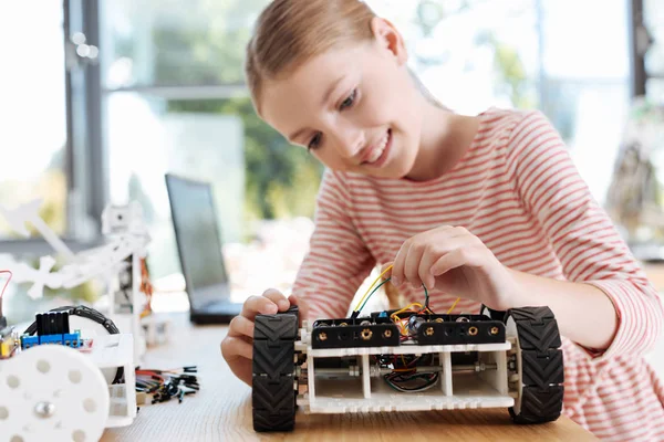 Εφηβικό κορίτσι αφαιρώντας τα καλώδια από το ρομποτικό όχημα — Φωτογραφία Αρχείου