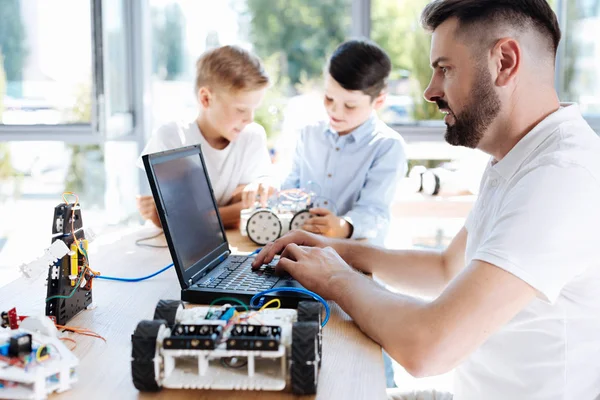 Jovem professor de robótica trabalhando no laptop — Fotografia de Stock