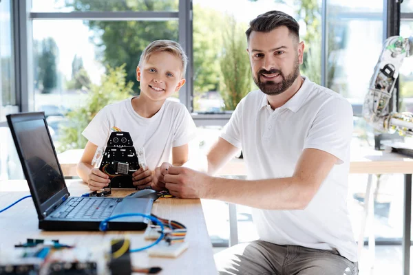 Joyeux élève assis près de son professeur de robotique — Photo