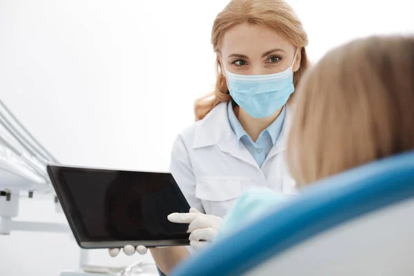 Lively enthusiastic doctor explaining something using her gadget — Stock Photo, Image