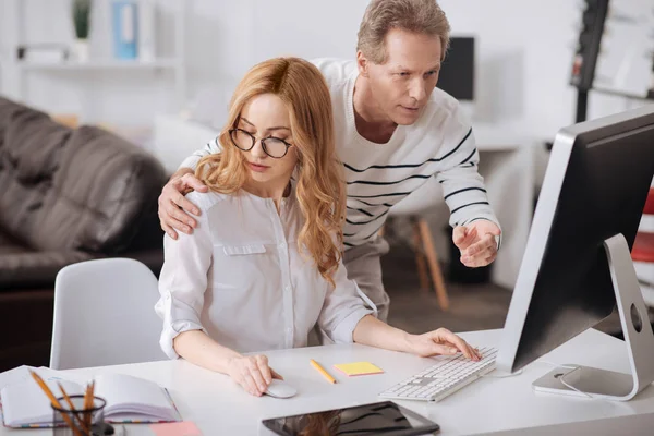 Coqueteando jefe abrazando joven secretaria en la oficina — Foto de Stock