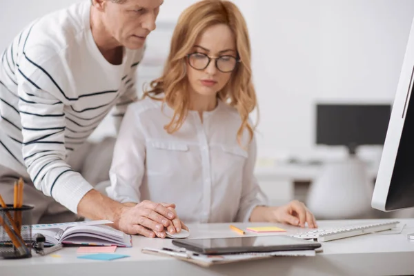 Positiv mogen affärsman flirta med ung kvinna på jobbet — Stockfoto