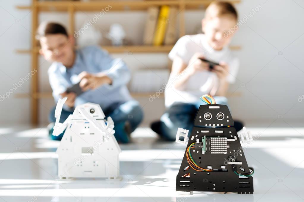 Two little friends conducting a robot race
