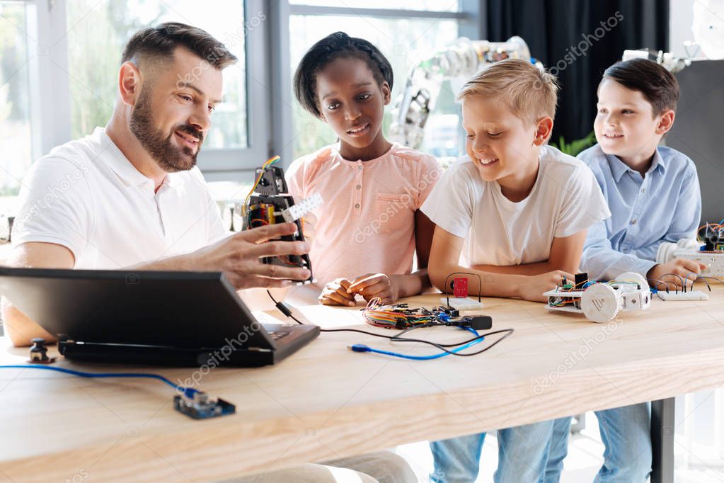 Pleasant robotics specialist conducting a workshop for children