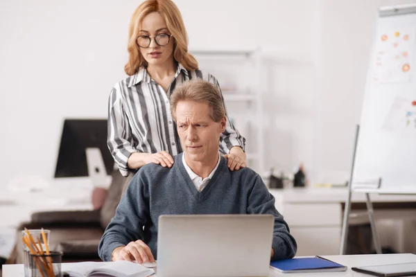 Behulpzame jonge zakenvrouw verleidelijke volwassen baas op kantoor — Stockfoto