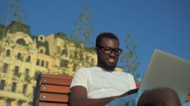 Parlak Afrikalı-Amerikalı adam diz laptop ile çalışma