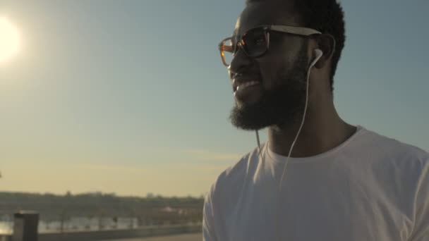 Крупним планом молодий чоловік з навушниками насолоджується музикою — стокове відео