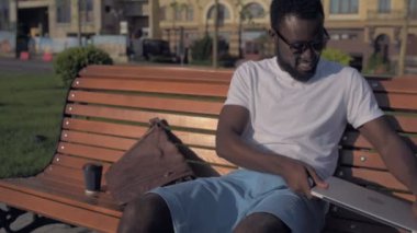 Rahatlatıcı ve yaygın olarak dizüstü bilgisayarda çalıştıktan sonra gülen heyecanlı adam