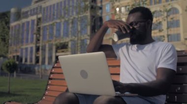 Dizüstü bilgisayarda çalışırken kahve içme adam