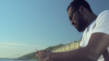 Smartphone kullanırken gülümseyen adam