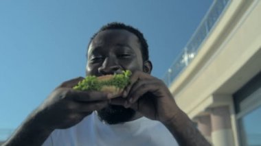 Afrika kökenli Amerikalı adam hamburger yemek 