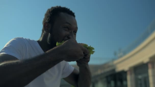 Афроамериканець людиною, насолоджуючись смачний обід — стокове відео