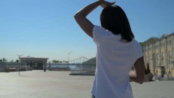Vrolijk meisje genieten van muziek tijdens haar promenade — Stockvideo