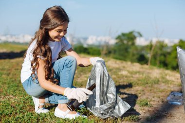 Çekici kız bir paket için çöp tutarak