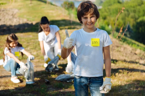 Muchacho encantado trabajando en grupo de voluntarios — Foto de Stock