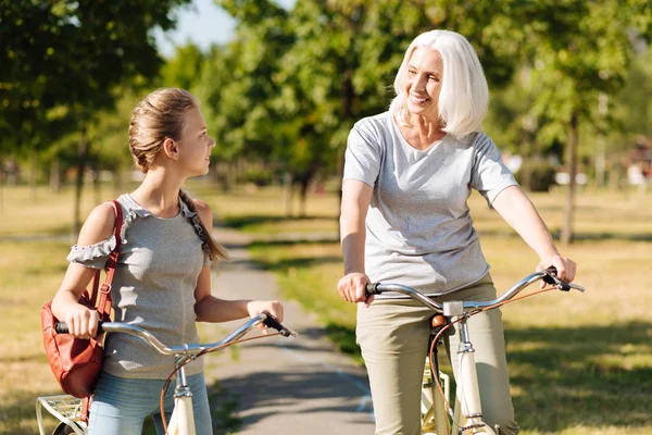 Woman riding bicycle with her granddaughter — Stock Photo, Image
