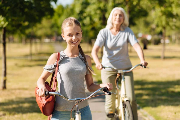Girl riding a bicycle with her grandmother — Stock Photo, Image