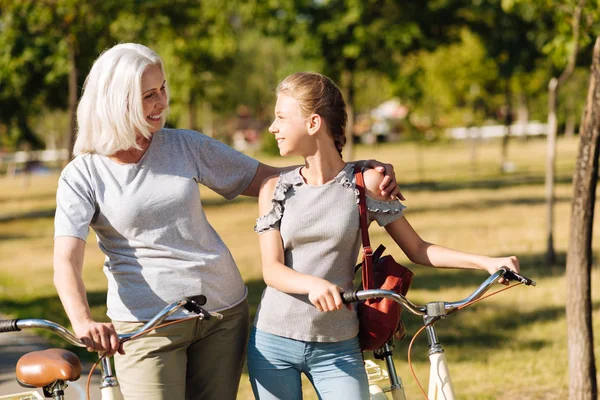 Woman riding bicycles with her granddaughter — Stock Photo, Image