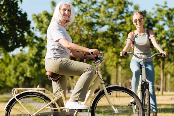 Женщина на велосипеде с внучкой — стоковое фото