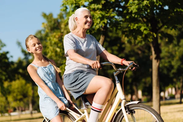Mujer montando a su nieta en la bicicleta — Foto de Stock