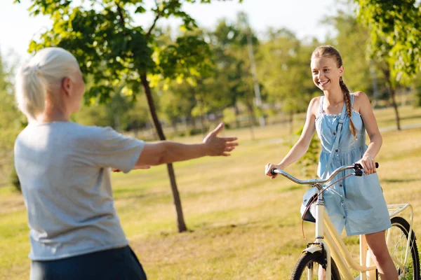 Menina se aproximando de sua avó na bicicleta — Fotografia de Stock