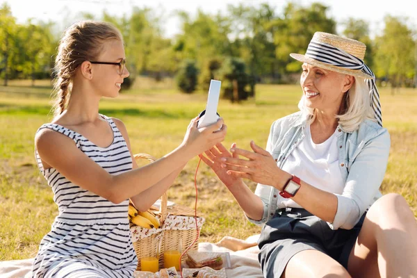 Mujer disfrutando de picnic con su abuela agradable — Foto de Stock