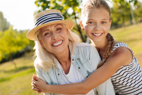 Ragazzina positiva che abbraccia sua nonna — Foto Stock