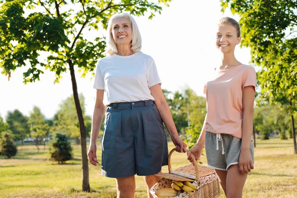Niña y abuela llevando una cesta de picnic —  Fotos de Stock