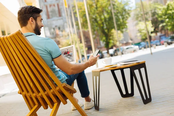 Tipo sentado en una terraza con gadgets — Foto de Stock