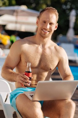 Soda yaparken dizüstü bilgisayarda çalışma çekici genç adam