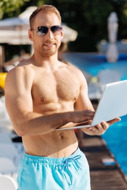 Adam ile onun laptop Yüzme Havuzu yanında ayakta uygun