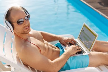 Genç adam güneş banyosu sırasında bir uygulama geliştirme