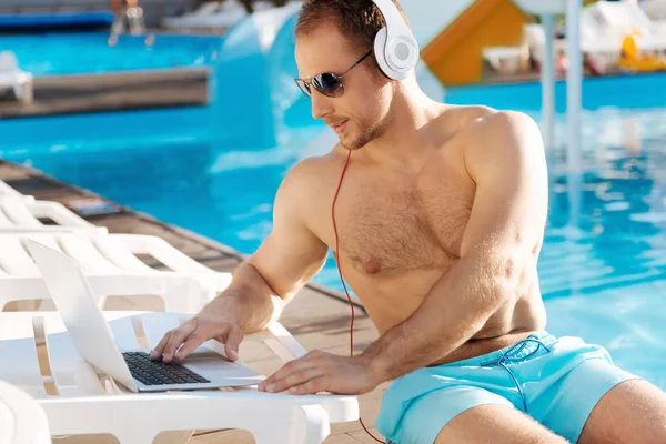 Yakışıklı adam Yüzme Havuzu yakınındaki bir video izlerken