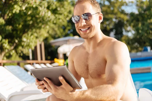 Hombre feliz sonriendo a la cámara mientras sostiene la tableta — Foto de Stock