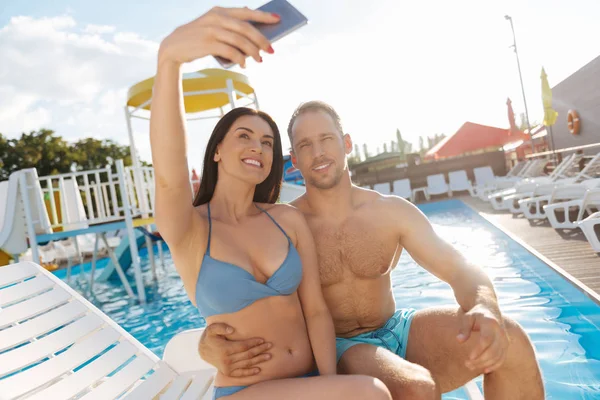 Hermosa pareja tomando selfie cerca de la piscina — Foto de Stock