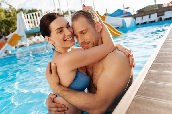 Loving man cuddling his girlfriend in swimming pool — Stock Photo, Image