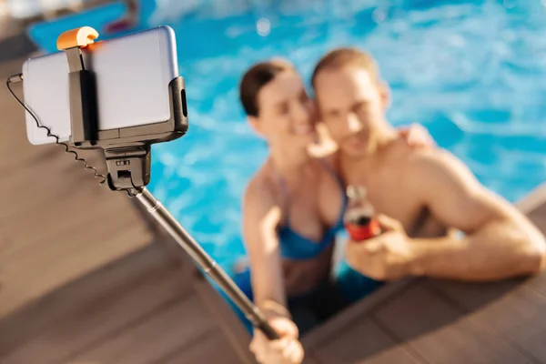 Pareja joven tomando una foto con selfie stick — Foto de Stock