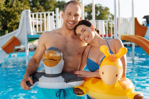 Happy couple wearing animal-shaped swim rings — Stock Photo, Image