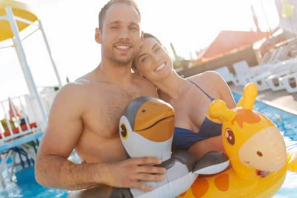 Happy couple in swim rings hugging each other — Stock Photo, Image