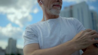 Kıdemli pozitif adam chosing koşu için bir şarkı