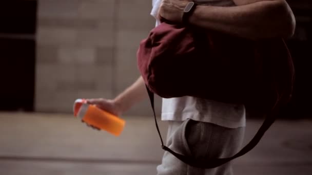 Agradable hombre deportivo caminando en la ciudad después del entrenamiento deportivo — Vídeos de Stock