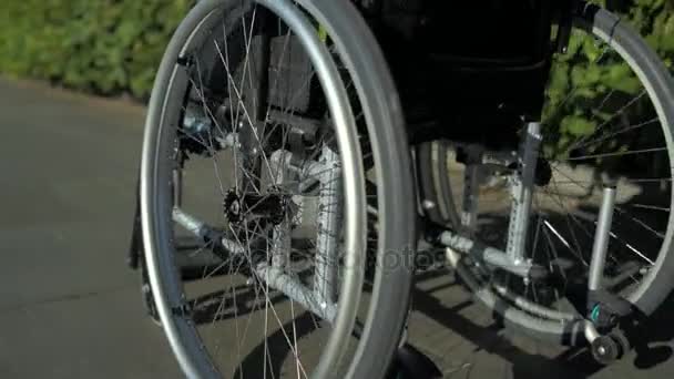 Kamerafahrt eines Rollstuhls im Park — Stockvideo