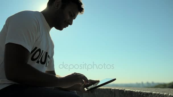 Bajo ángulo de un voluntario concentrado usando la tableta — Vídeos de Stock