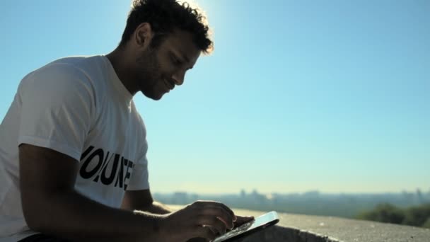 Alegre voluntario masculino usando la tableta al aire libre — Vídeos de Stock