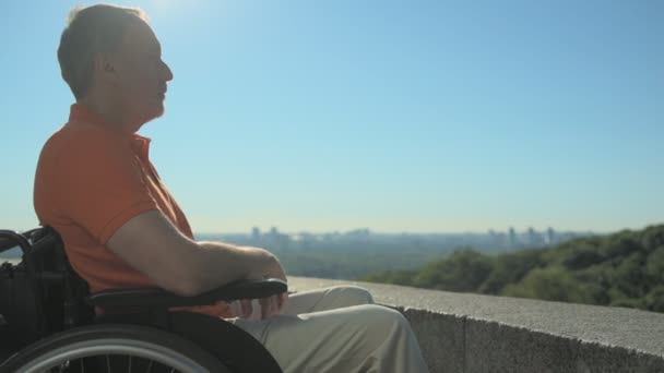 Kellemes koncentrált wheelchaired ember élvezi a város, a megfigyelési pont — Stock videók